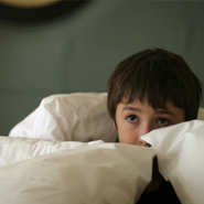 kid hidding in pillows