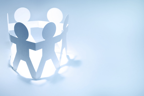 Team of paper doll people holding hands