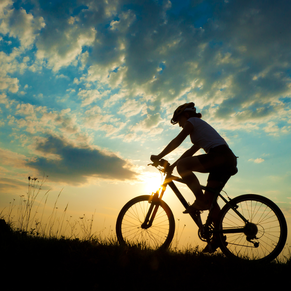 Woman riding bike at sunset: Enter key opens full-screen view with caption; escape key exits full screen.