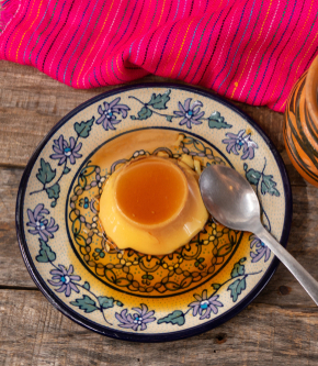 Traditional vanilla flan dessert on wooden background.