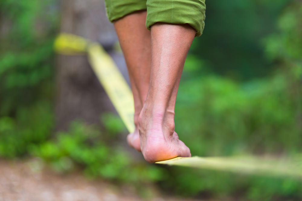Person's feet balancing on cloth wire