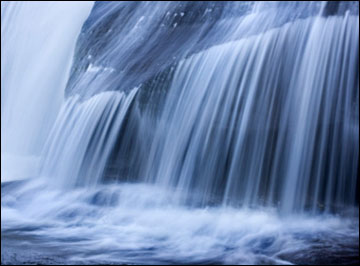 A waterfall rushing out from rocks 
