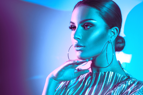 High fashion model posing under colorful bright lights.