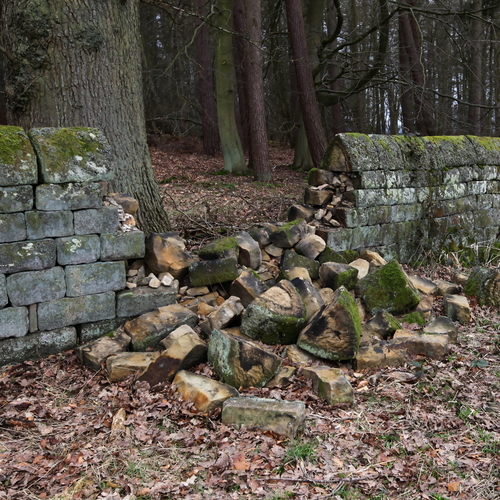 An old dry stone wall that has collapsed and requires repair