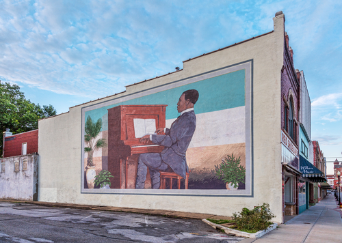 A mural Scott Joplin playing 'Maple Leaf Rag' on the piano.