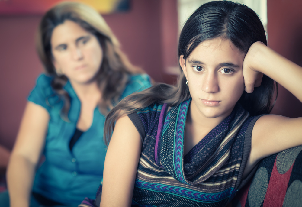 Defiant teenage girl after a fight with her worried mother.