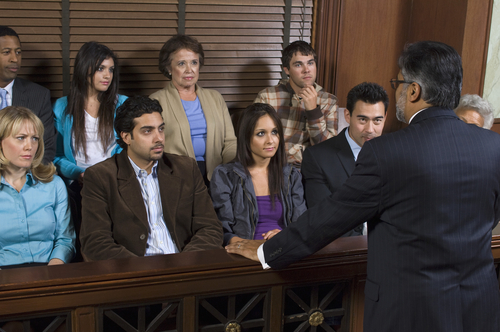 Rear view of a advocate communicating with the jurors in the court house