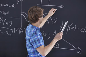student working on a math problem on chalkboard