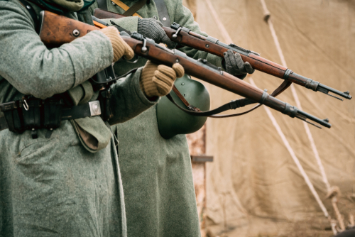 Soldiers of the Wehrmacht in greatcoats with rifles in their hands.