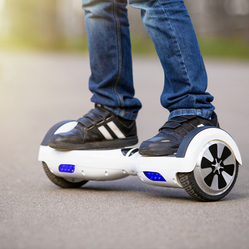 Boy on electrical scooter outdoors.