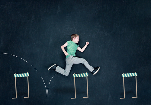 A boy jumping over hurdles. Use enter key to open full-screen view.