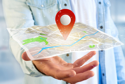 View of a someone holding a 3d rendering pin holder on a map