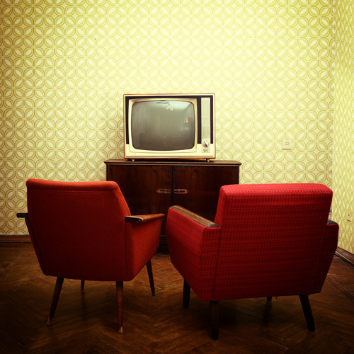 Vintage room with two old fashioned armchairs and retro tv.