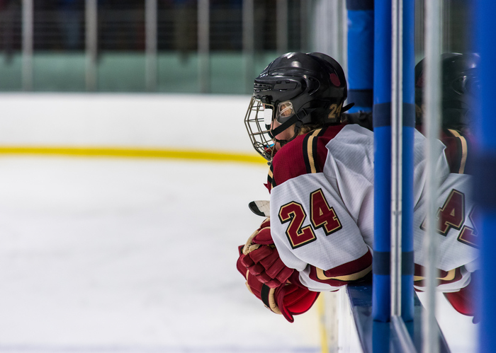 hockey player leaning over railing