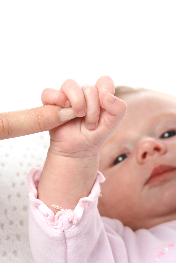 Photo of baby holding a finger