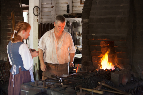 Williamsburg, Virginia, USA - 6/23/2009: A man dressed in period clothing is demonstrating blacksmith activities in colonial Williamsburg.