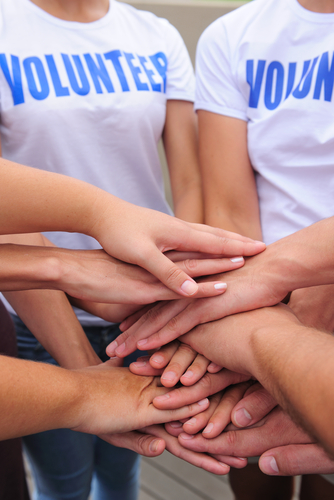 Volunteer group hands together showing unity.