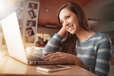 girl smiling as she looks at a website