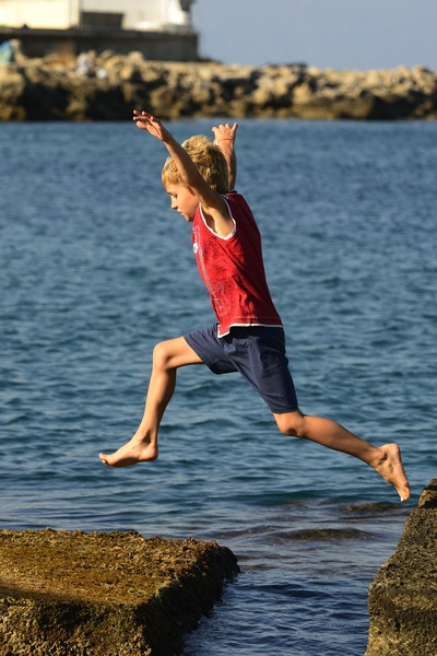 Child jumping from rock to rock