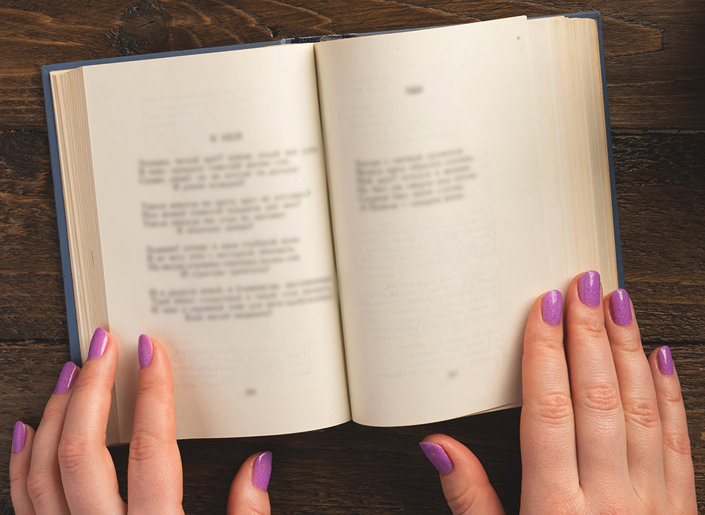 Close up of hands on an opened book.