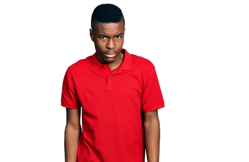 Man wearing casual red t shirt skeptic and nervous, frowning upset because of problem. negative person.