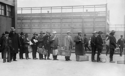Italian men await admission processing at Ellis Island in 1910