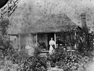 Woman standing in the homestead garden at Camboon Station, 1871 Dawson River property originally taken up by Jame Reid in 1856 and acquired in 1874 by Messrs. J. T. M. Bell and Collville Hyde. (Description supplied with photograph.).