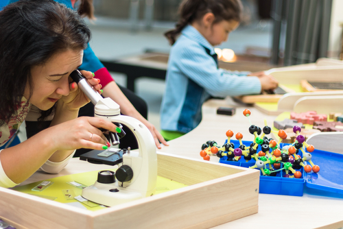 June, 2017. Minsk. Belarus. Museum of Science in the National Library. A woman and children look at the molecules in a microscope. STEM education.