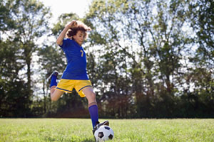 boy kicking soccer ball
