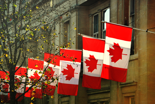 a row of Canadian flags outside Canada House in Trafalgar Square, London