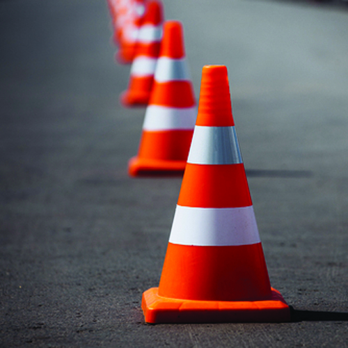 a number of conical orange and white traffic cones
