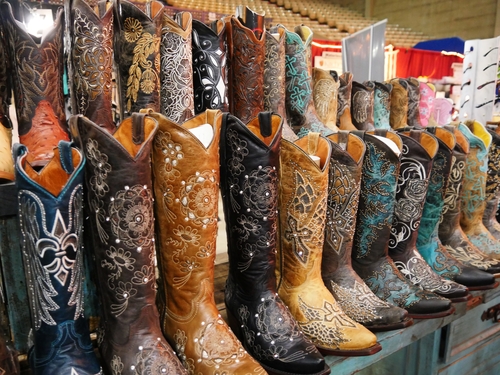 A row of colorful artistically designed knee-high boots displayed inside one of the buildings at the State Fair of Texas carnival grounds in Dallas.