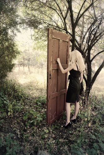 Mystical place. Girl in front of the magic door in the forest