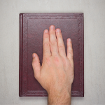A man's palm on a book, an oath on the bible.