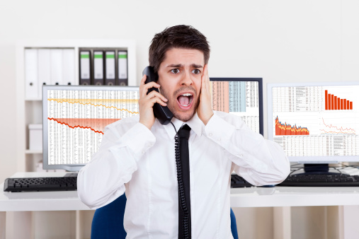 Man on phone shocked because of failing stocks..