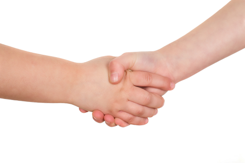 School kids shaking hands. Handshake isolated on a white background.