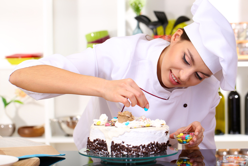 A young chef working on a cake in the kitchen.