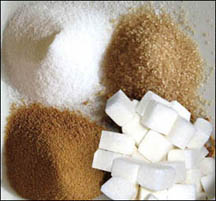Sugar in four piles of raw, white, brown and cubed