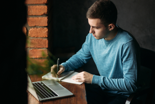 Student working and writing down something in the notebook.