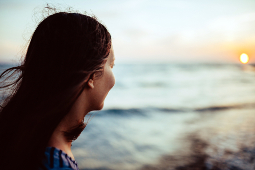 Young woman looking at sunset.