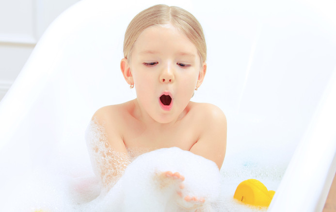Child taking bath with bubbles