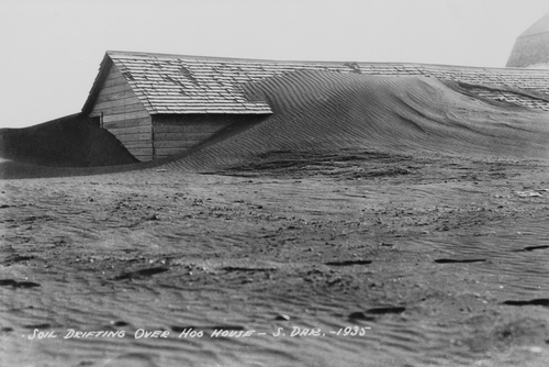 Soil drifting over a farm building on a South Dakota farm in 1935.