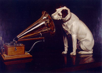 Dog listening to owner's voice over record player.