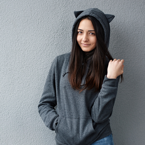 A girl in hood with cat's ears smiling.