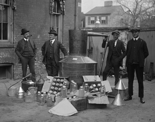 Prohibition agents stand with a still and mason jars used to distill hard liquor in the Washington, D.C.