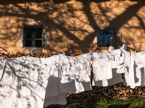 Clothes line full of reusable baby diapers in front of the house.