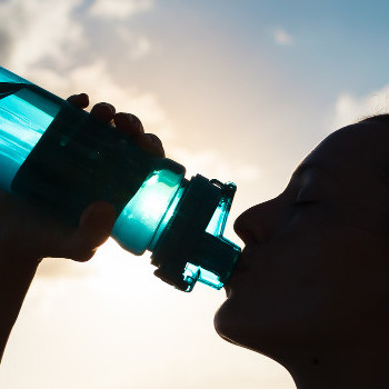 person drinking water from a bottle