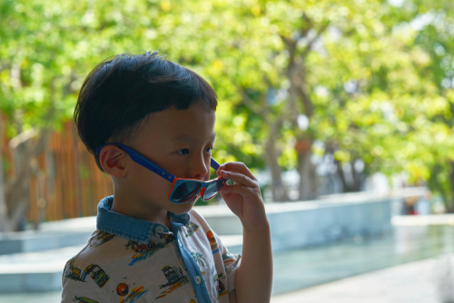 Boy is taking off sunglasses while in travelling trip