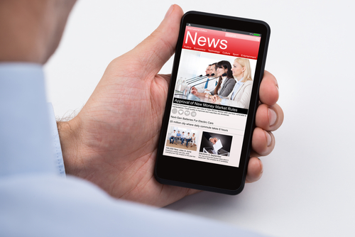Close-up Of Businessperson Reading Online News On Mobile Phone