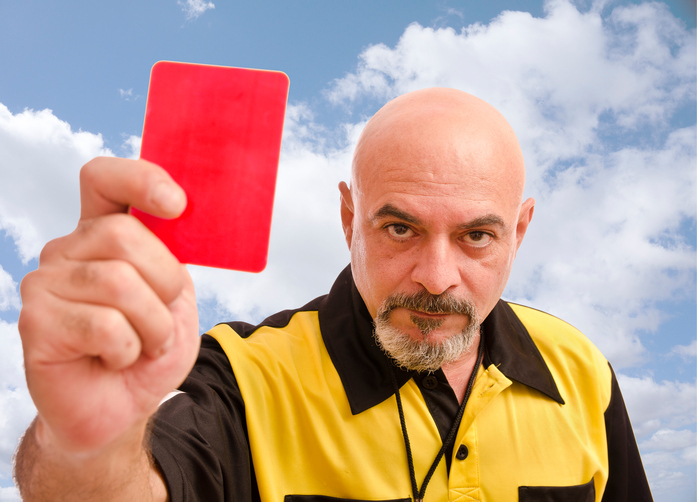 referee holding yellow card